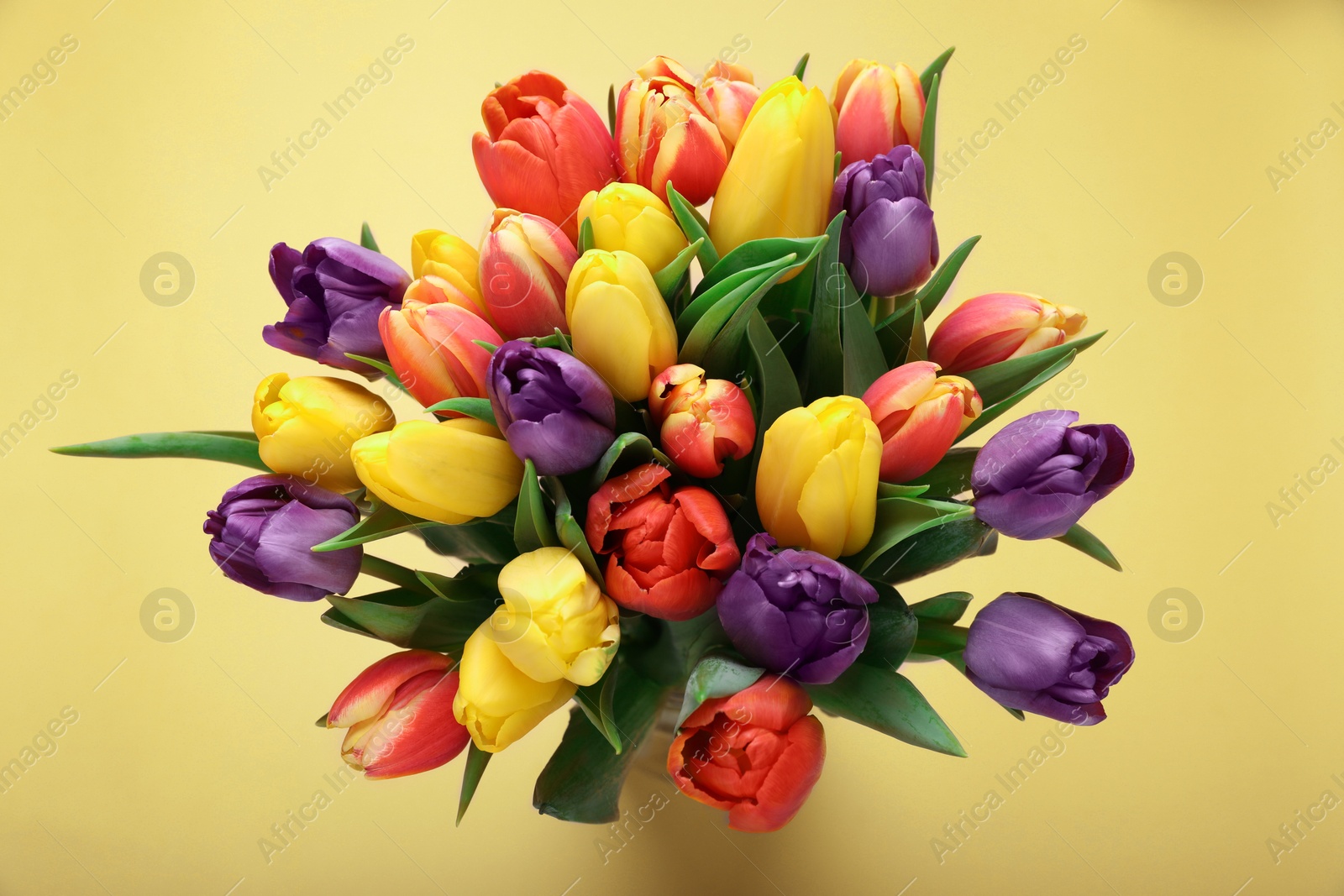 Photo of Bouquet of beautiful tulips on beige background, top view