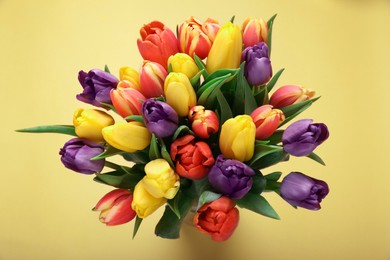 Bouquet of beautiful tulips on beige background, top view