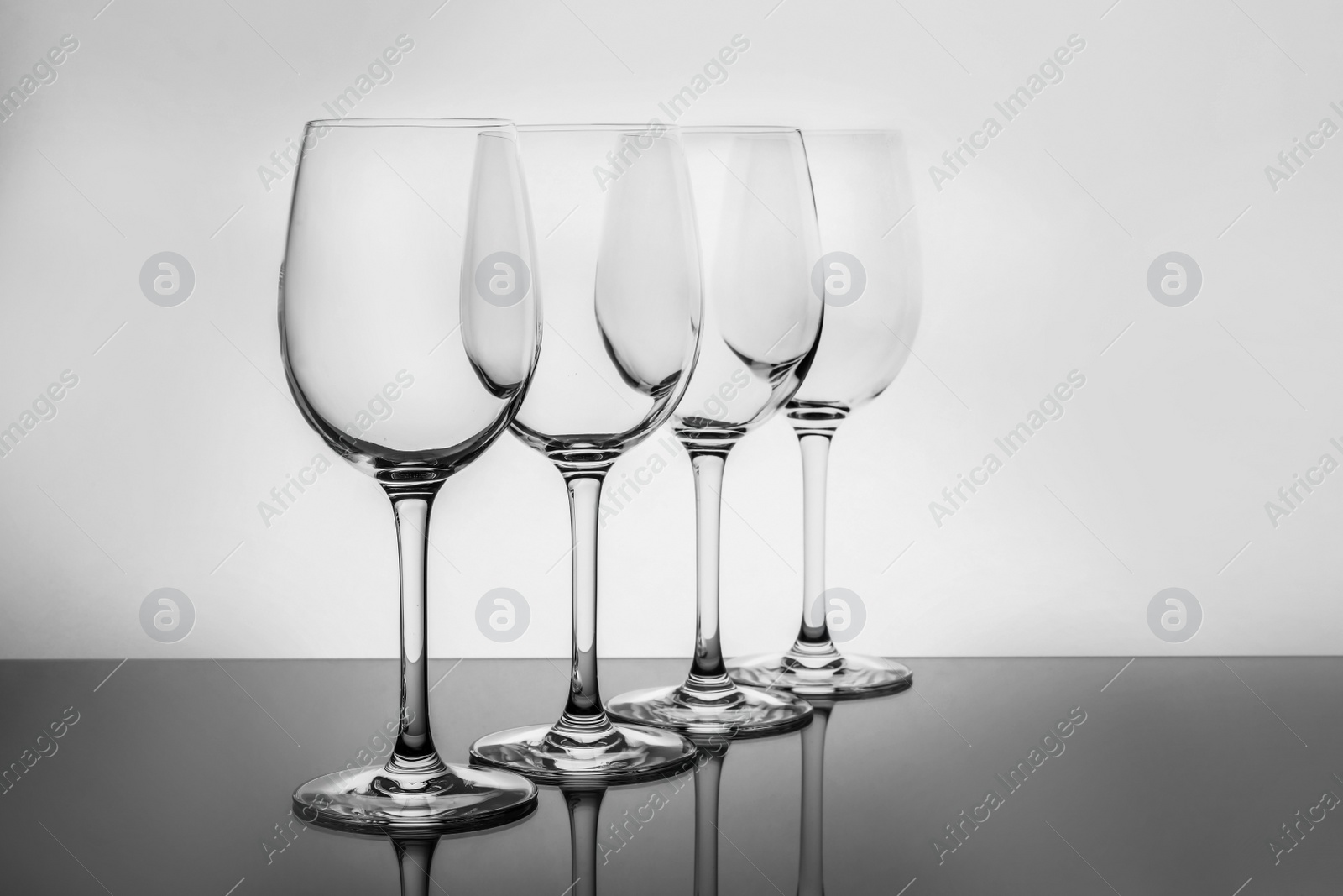 Photo of Row of empty wine glasses on white background