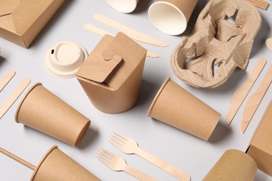 Photo of Eco friendly food packaging. Paper containers and tableware on light grey background