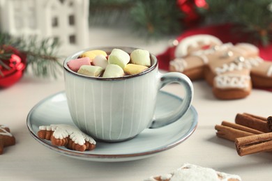 Delicious hot chocolate with marshmallows and gingerbread cookies on white wooden table, closeup