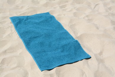 Beautiful soft blue towel on sandy beach