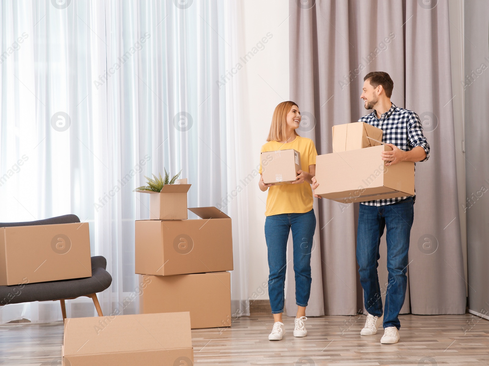 Photo of Couple with moving boxes in their new house