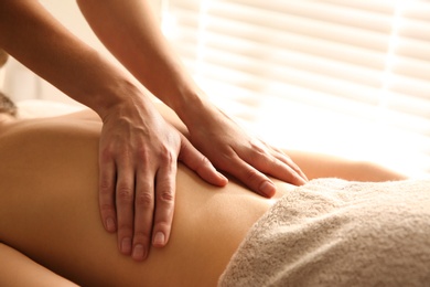 Photo of Young woman receiving back massage in spa salon, closeup