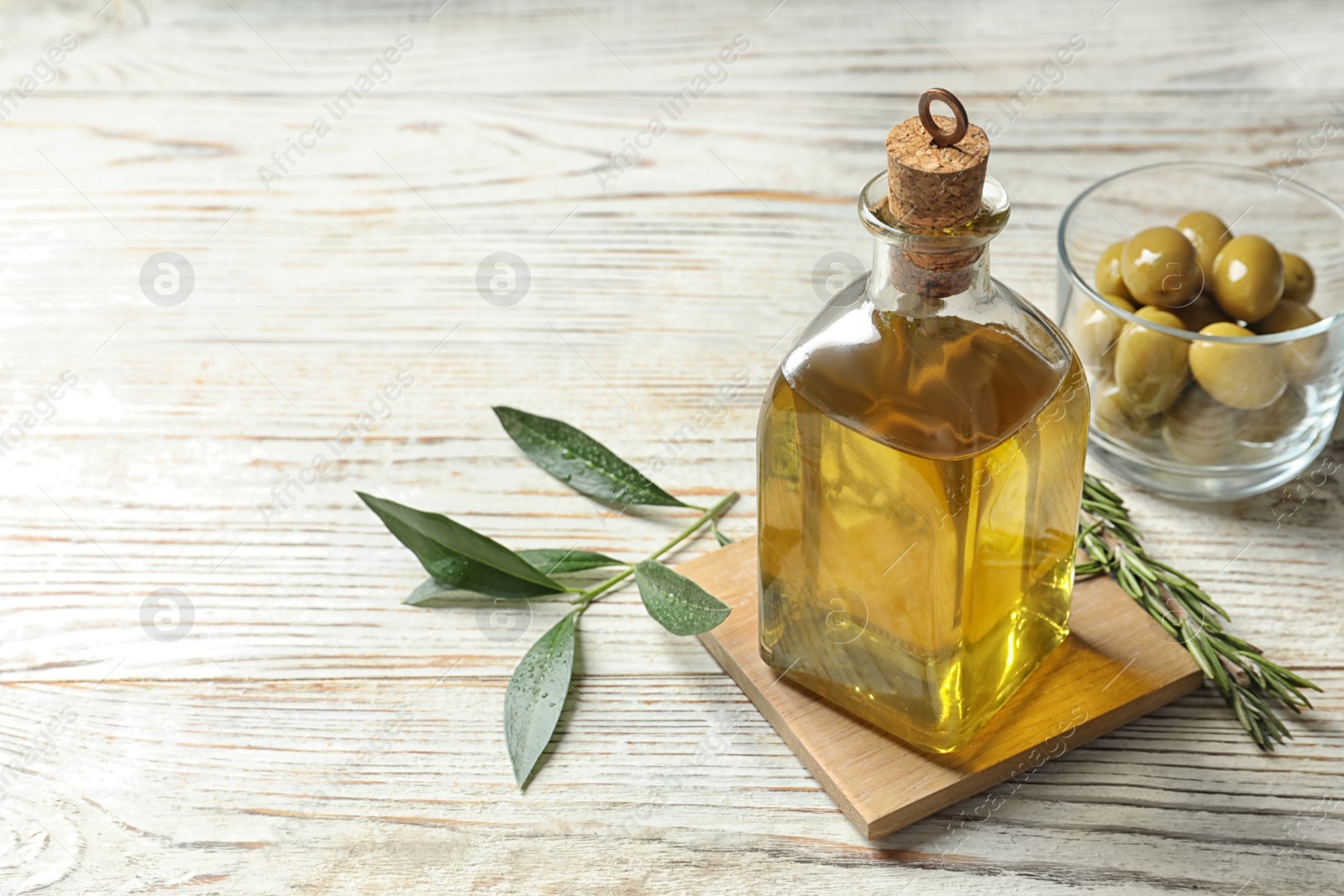 Photo of Bottle with fresh olive oil on table