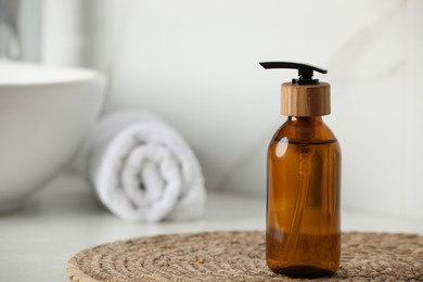 Photo of Bottle with dispenser cap on table in bathroom, closeup. Space for text