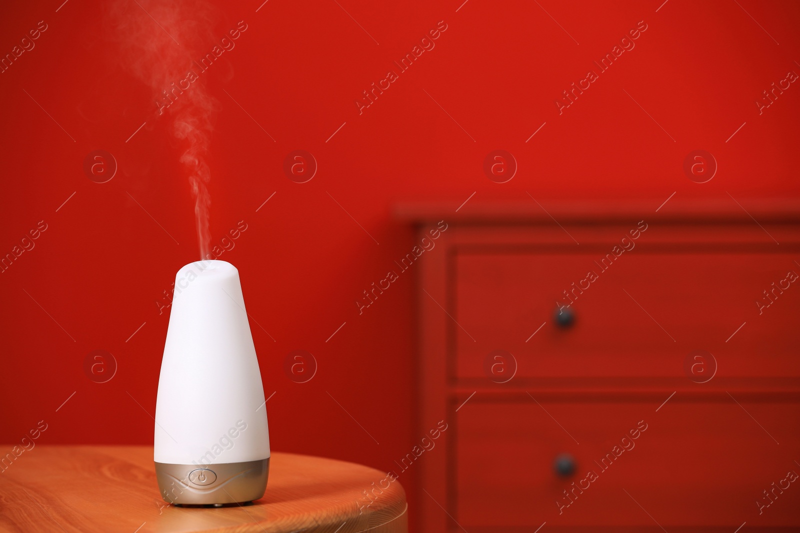 Photo of Modern essential oil diffuser on table indoors. Space for text