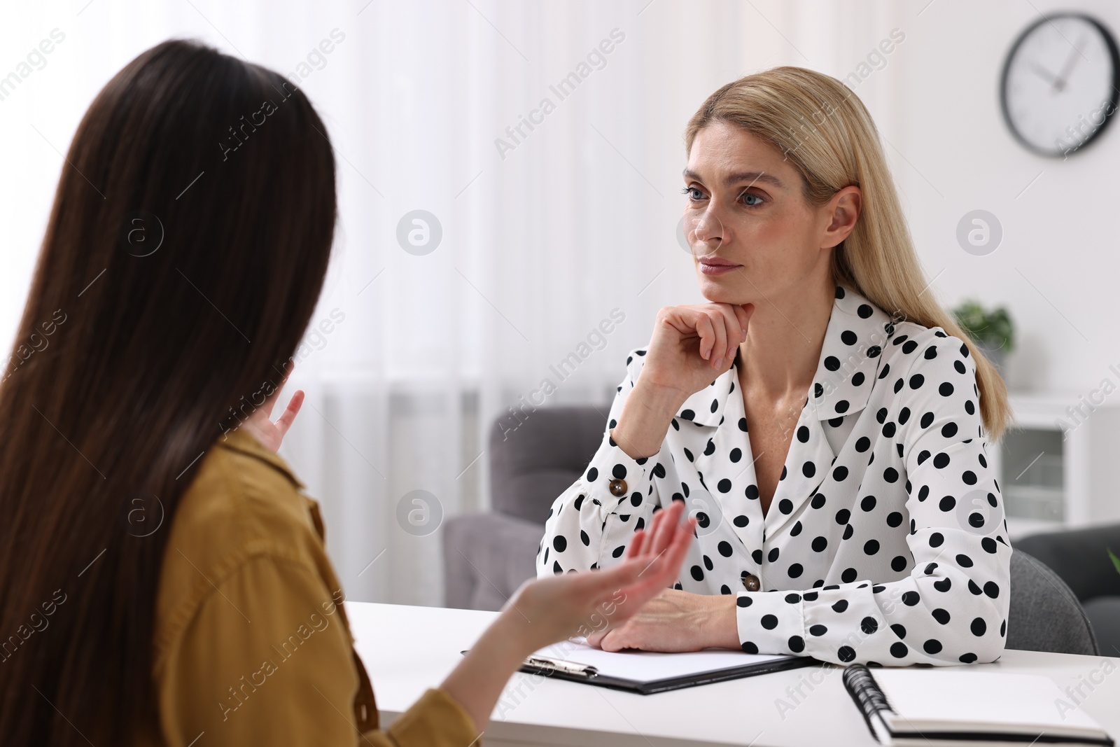 Photo of Psychologist working with teenage girl at table in office