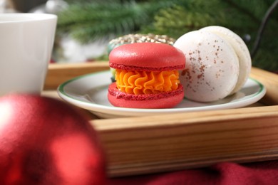 Different decorated Christmas macarons on table, closeup