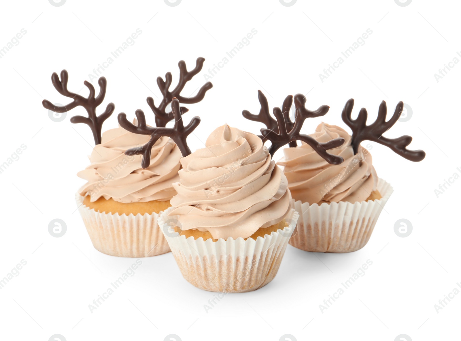 Photo of Delicious Christmas cupcakes with chocolate reindeer antlers on white background