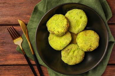 Tasty vegan cutlets served on wooden table, top view