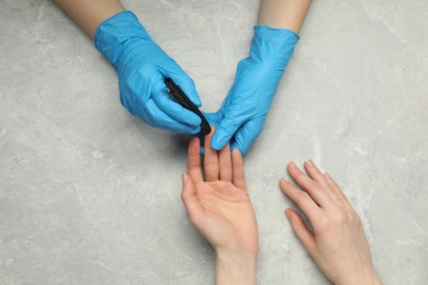 Diabetes. glucose testing. Doctor using lancet pen at light table, top view