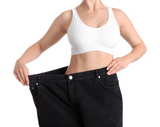 Photo of Young slim woman wearing oversized jeans on white background, closeup