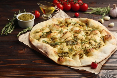 Photo of Traditional Italian focaccia bread with guacamole and rosemary on  wooden table