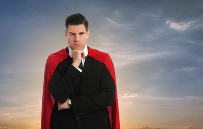 Image of Confident man wearing superhero cape against beautiful sky, space for text