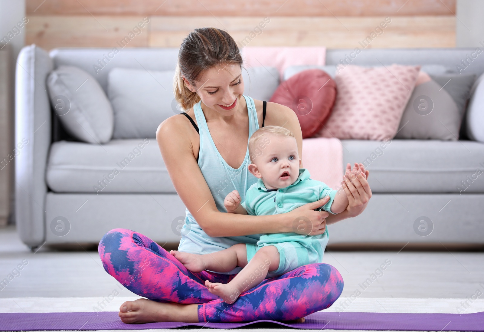 Photo of Young sportive woman doing exercise with her son at home. Fitness training