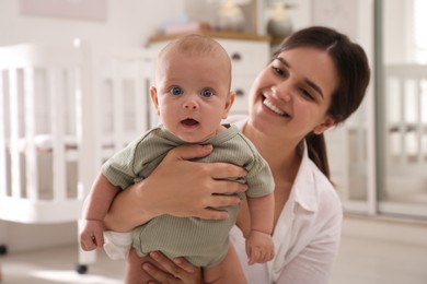 Happy young mother with her cute baby at home