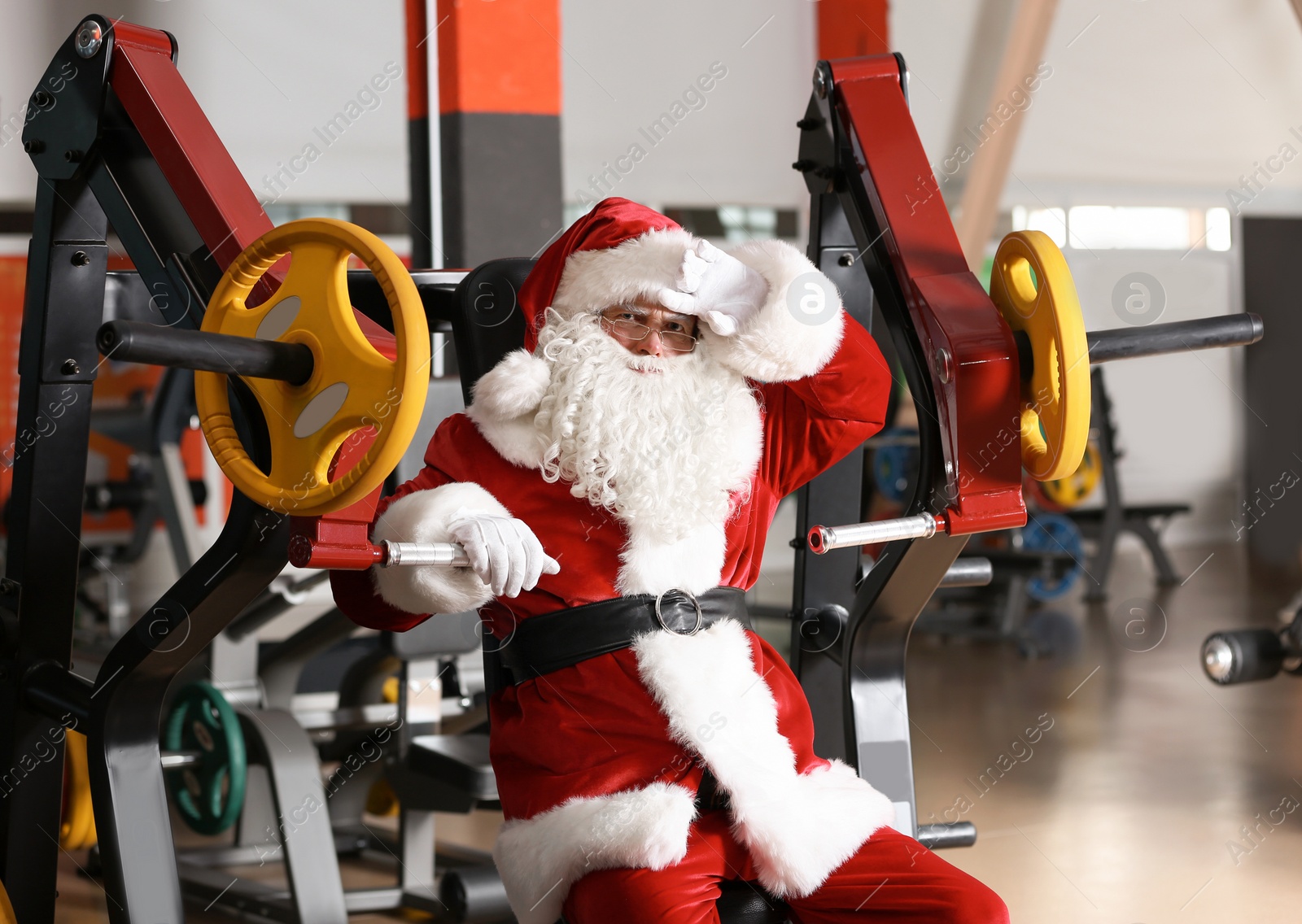 Photo of Authentic Santa Claus resting after exercise in modern gym