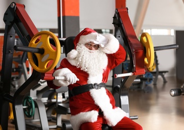 Authentic Santa Claus resting after exercise in modern gym