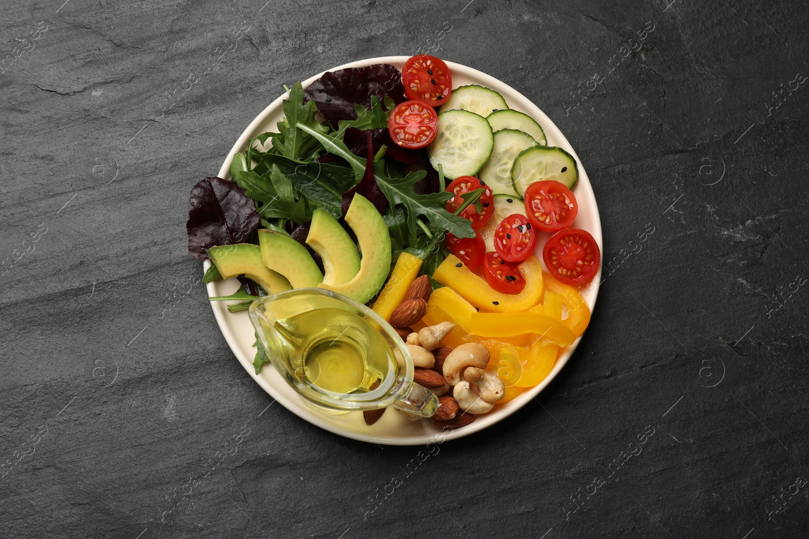 Photo of Balanced diet and vegetarian foods. Plate with different delicious products on black table, top view