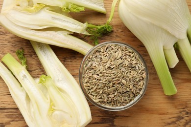 Photo of Fennel seeds in bowl and fresh vegetables on wooden table, flat lay