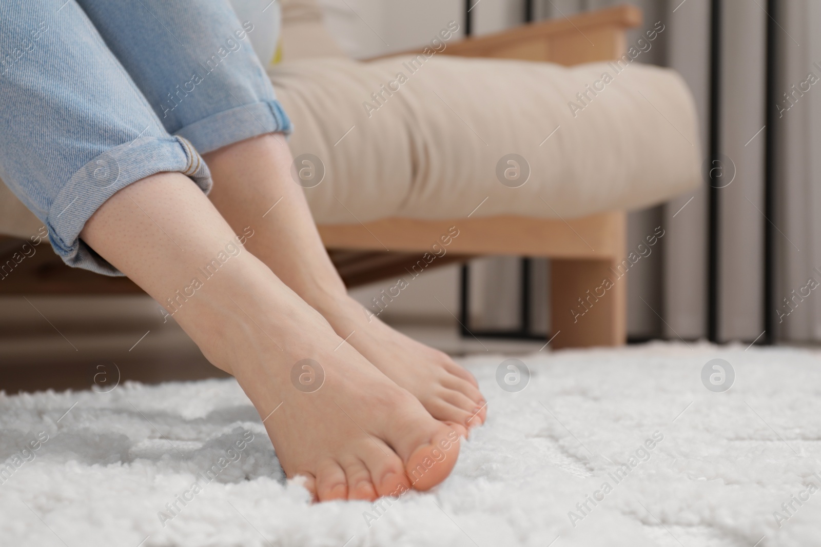 Photo of Woman sitting on sofa near beige carpet indoors, closeup. Space for text