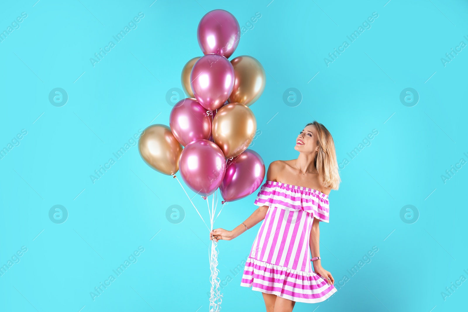 Photo of Young woman with air balloons on color background