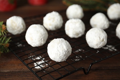 Photo of Tasty snowball cookies on cooling rack, closeup. Christmas treat