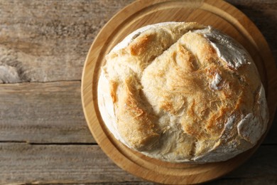 Photo of Freshly baked sourdough bread on wooden table, top view. Space for text