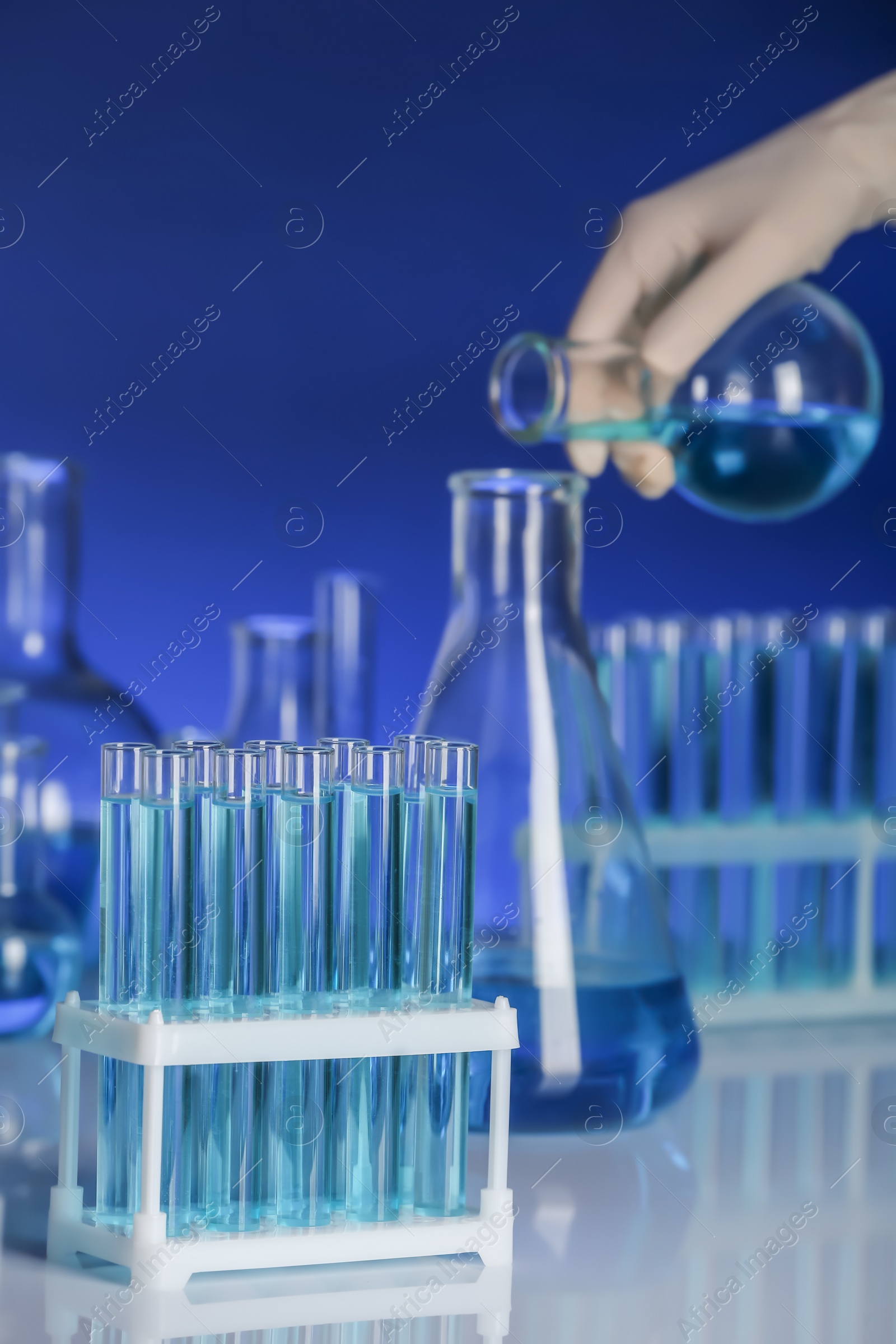 Photo of Holder with test tubes and scientist on background. Laboratory analysis