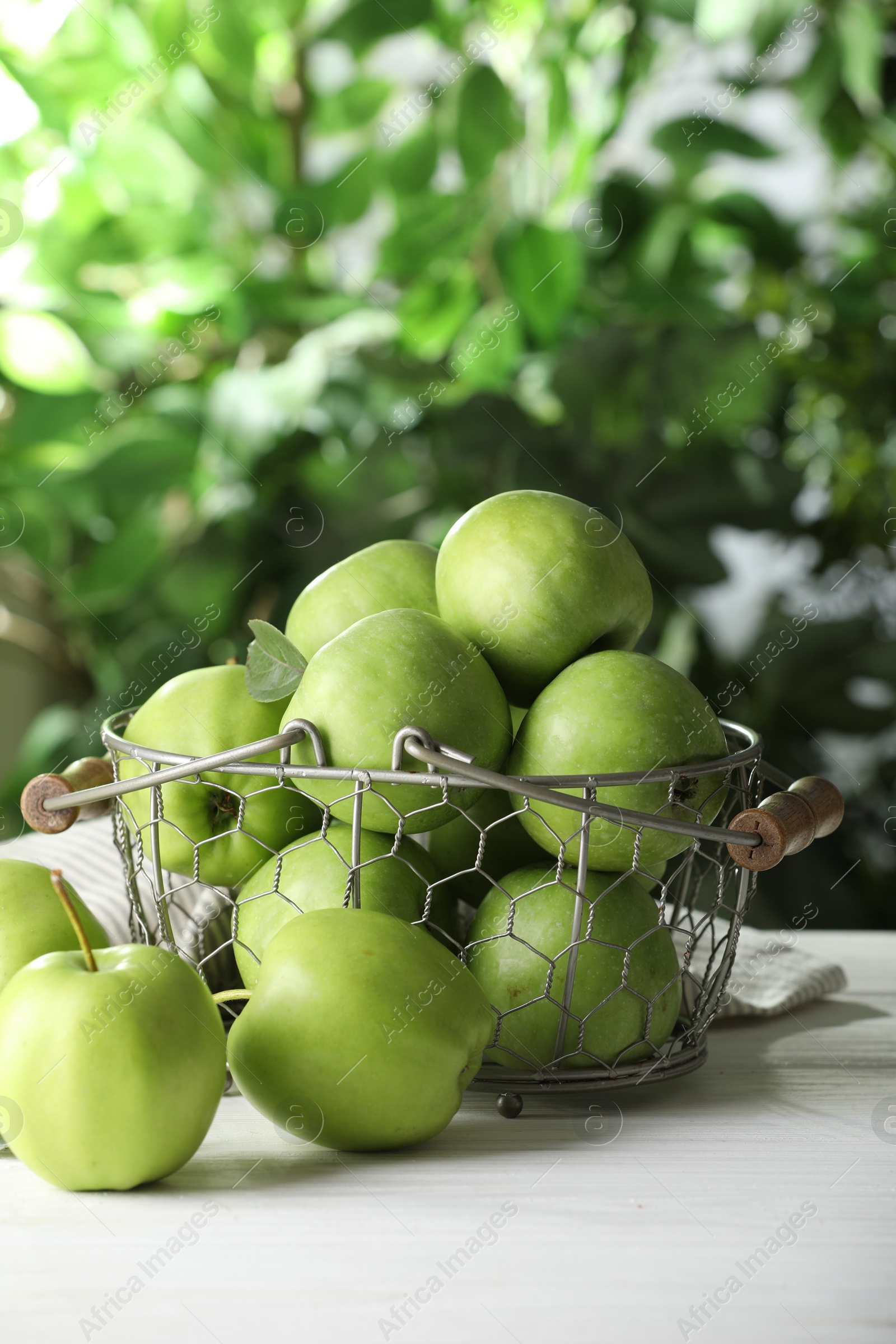 Photo of Ripe green apples on white table outdoors