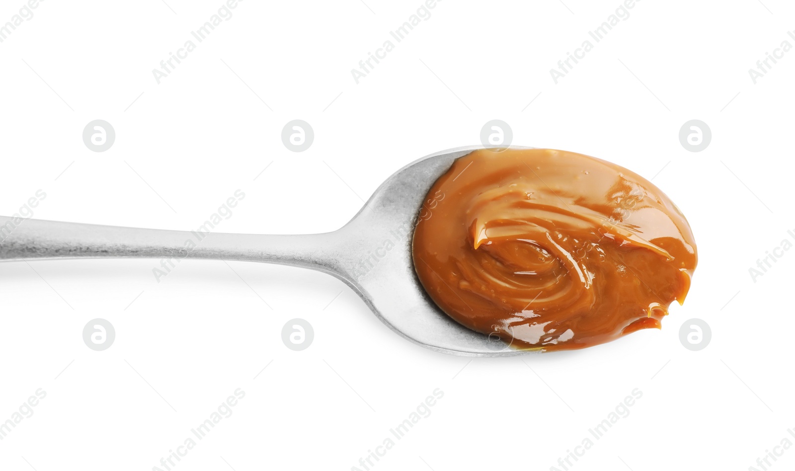 Photo of Spoon with tasty boiled condensed milk isolated on white, top view