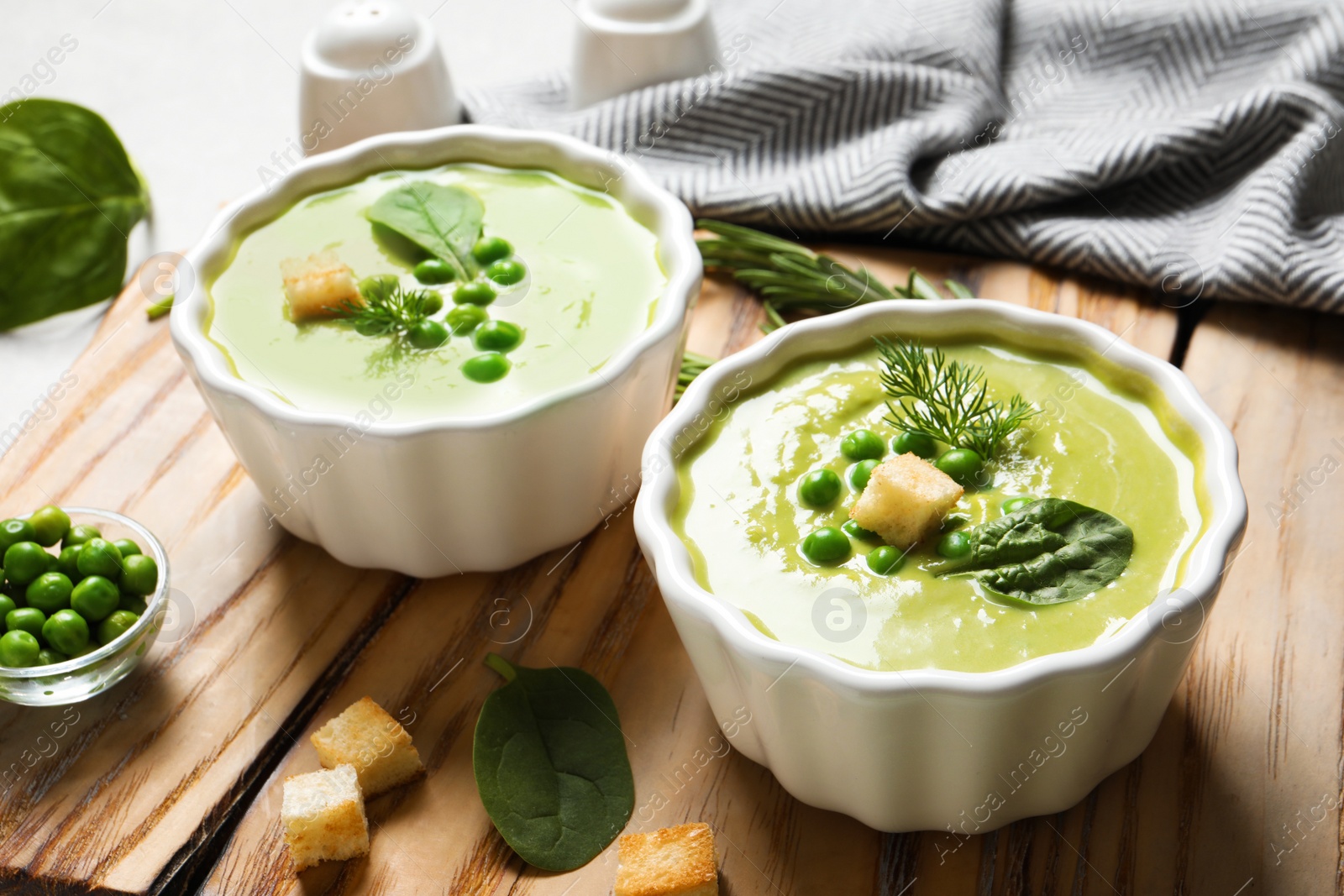 Photo of Fresh vegetable detox soup made of green peas and spinach with croutons served on board