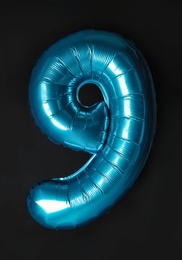 Blue number nine balloon on black background