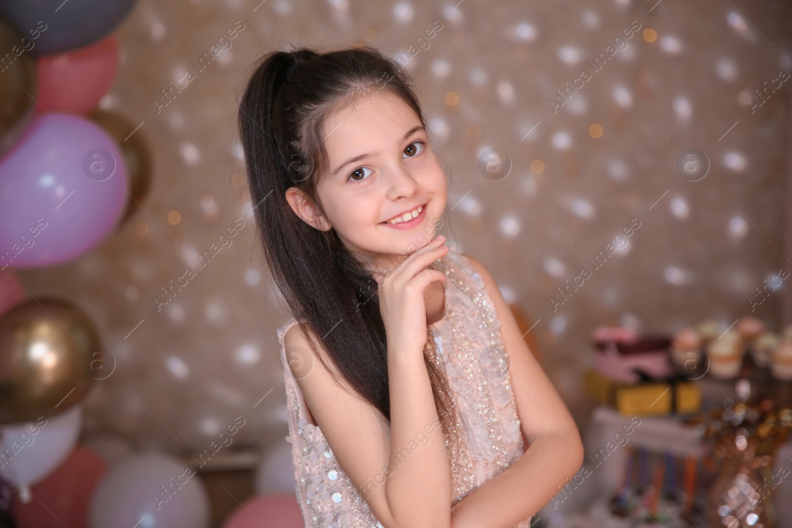 Photo of Happy little girl in beautifully decorated room at home. Birthday celebration