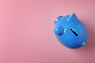 Photo of Blue piggy bank on color background, top view