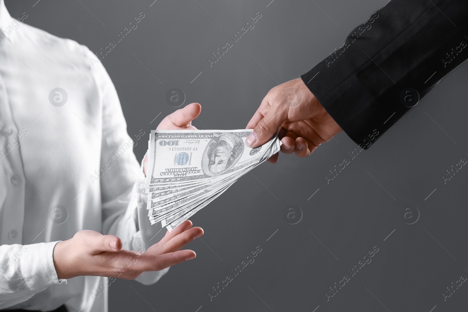 Photo of Man giving bribe money to woman on dark background, closeup