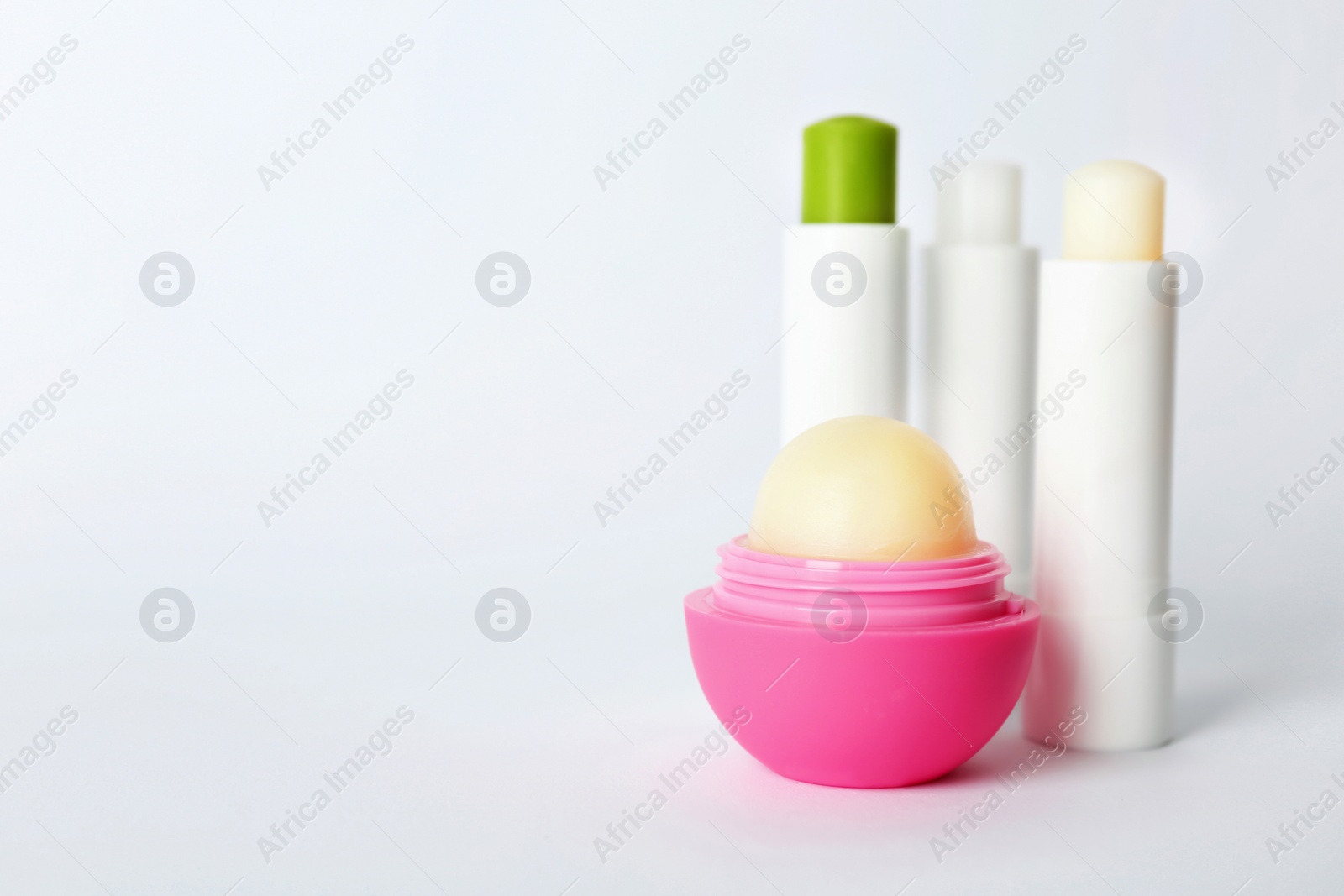 Photo of Hygienic lipsticks and balm on white background