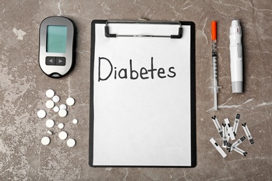 Photo of Flat lay composition with word DIABETES, digital glucometer and lancet pen on grey background