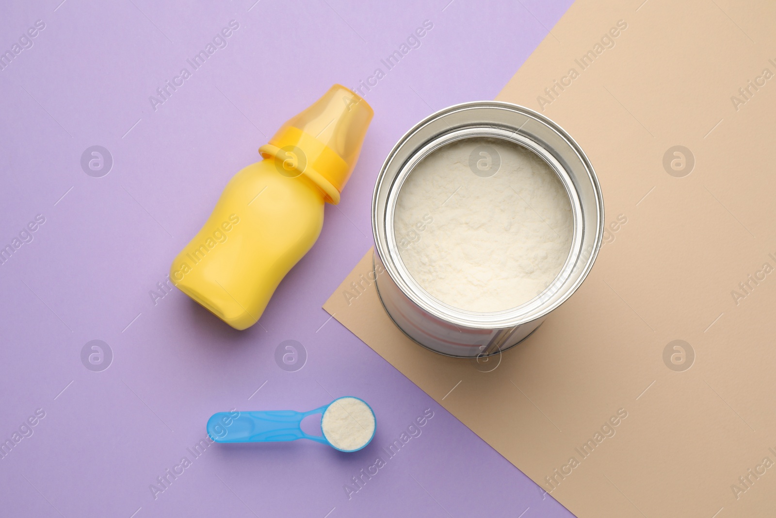 Photo of Feeding bottle with infant formula and powder on color background, flat lay