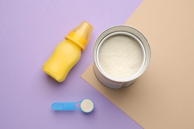 Photo of Feeding bottle with infant formula and powder on color background, flat lay