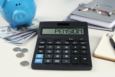 Photo of Calculator, piggy bank, money, glasses and notebooks on white table. Pension planning