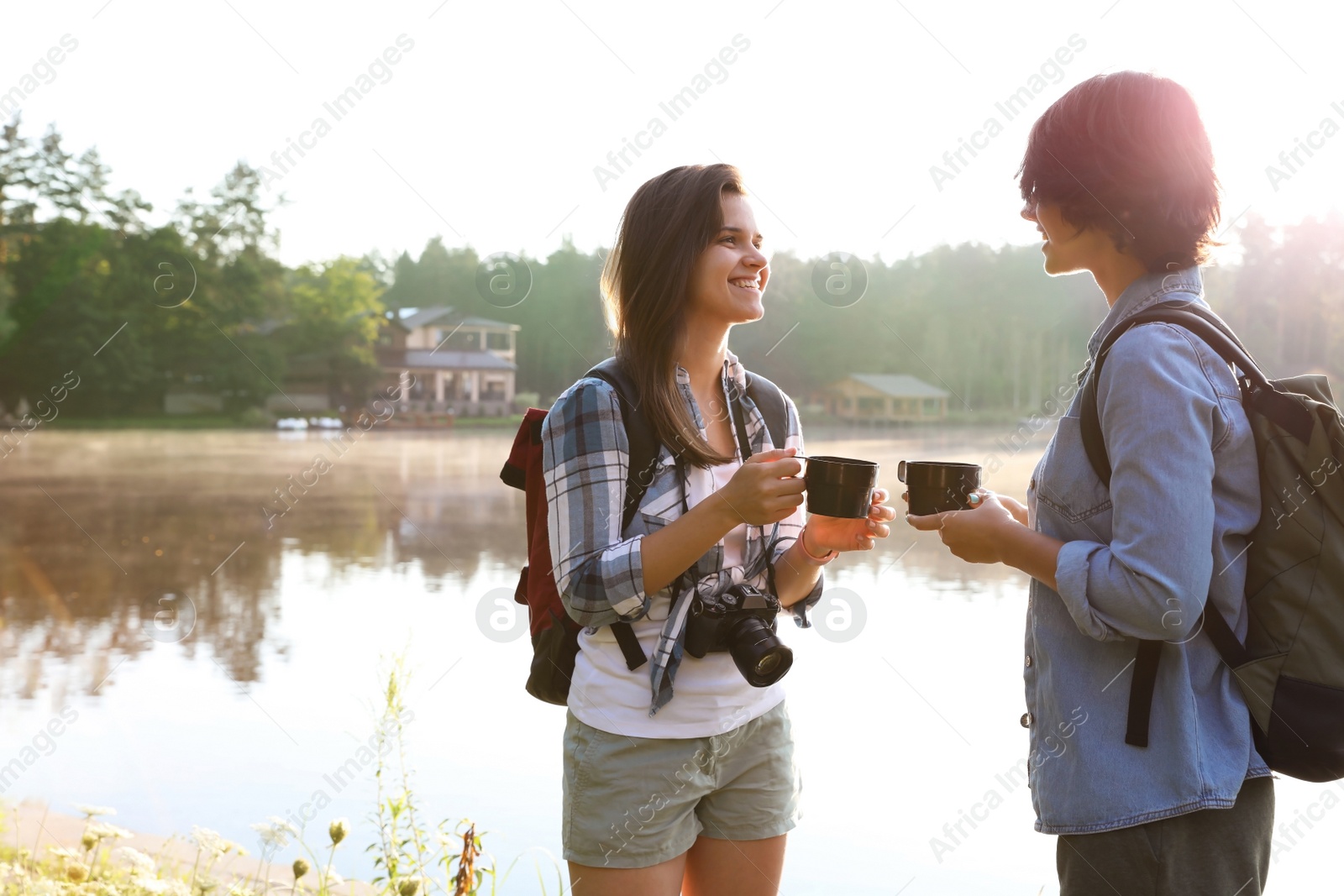 Photo of Young friends on shore of beautiful lake. Camping season