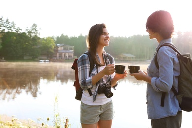 Young friends on shore of beautiful lake. Camping season