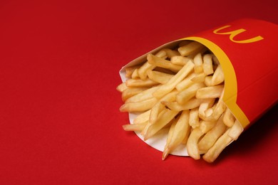 Photo of MYKOLAIV, UKRAINE - AUGUST 12, 2021: Big portion of McDonald's French fries on red background, closeup. Space for text