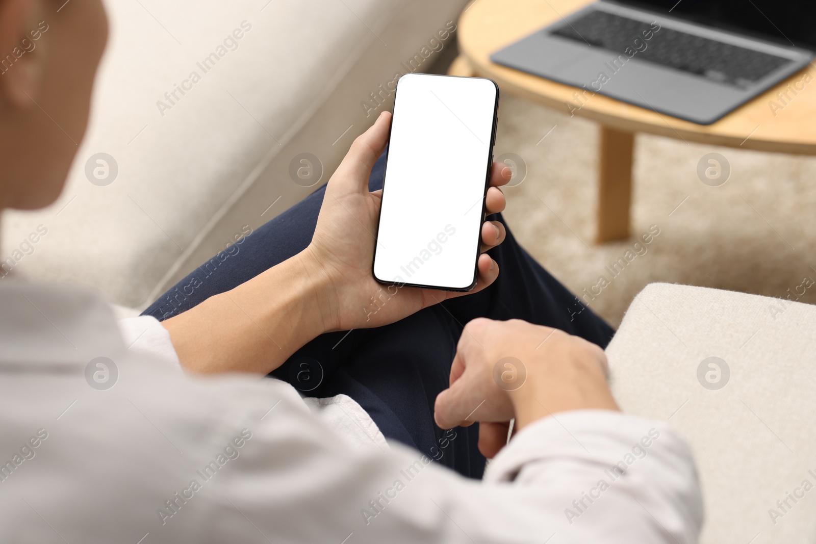 Photo of Man using smartphone with blank screen indoors, closeup. Mockup for design