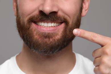 Photo of Man showing healthy gums on gray background, closeup