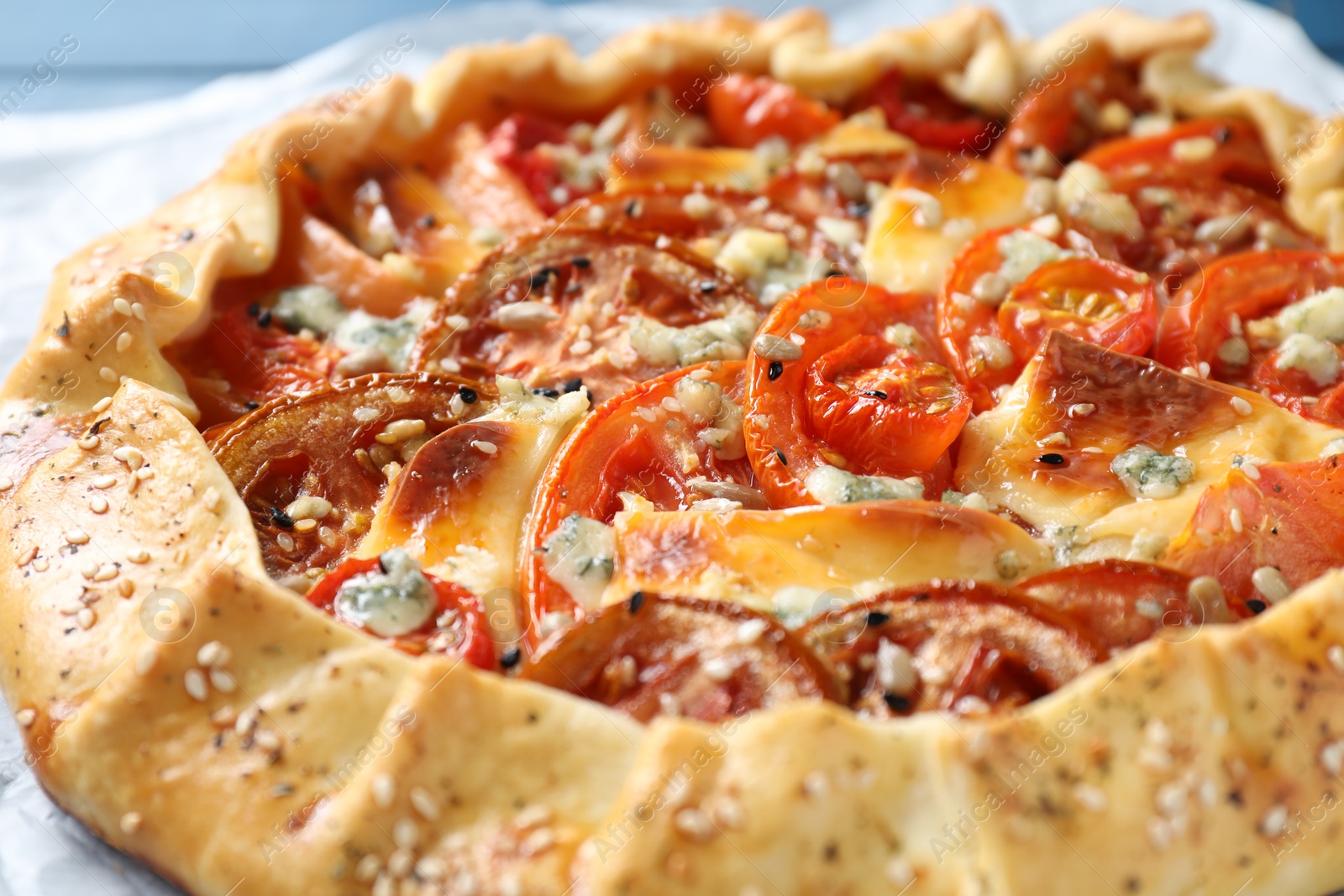 Photo of Tasty galette with tomato and cheese (Caprese galette) on table, closeup