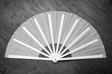Photo of Stylish white hand fan on grey background, top view