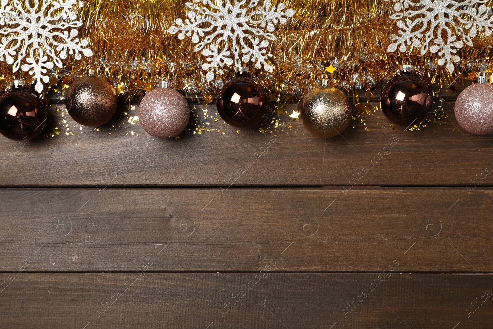 Photo of Bright tinsel and Christmas decor on wooden background, flat lay. Space for text